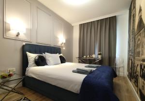 a bedroom with a large bed with a blue headboard at Prestige Apartment Słupsk in Słupsk