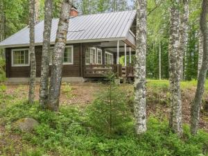una cabaña de madera en el bosque con árboles en Holiday Home Laitamökki by Interhome, en Tasapää