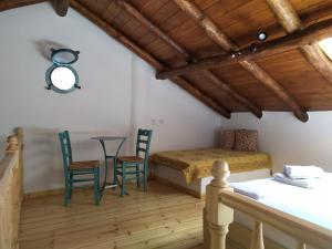 スキアトスタウンにあるSkiathos island houseのベッドルーム1室(ベッド1台、椅子2脚、テーブル付)