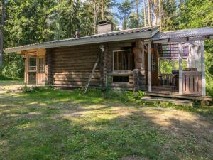 een kleine blokhut in het bos met een veranda bij Holiday Home Lemmenmaja by Interhome in Paatela