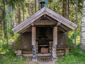 een blokhut met een bel in het bos bij Holiday Home Lemmenmaja by Interhome in Paatela