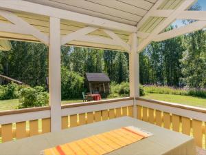 a screened in porch with a table and a gazebo at Holiday Home Rauhalinna by Interhome in Paatela
