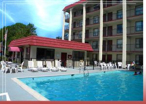 a hotel with a swimming pool in front of a building at Cerca Del Mar Motel in Virginia Beach