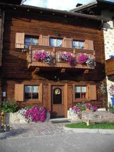 a wooden house with flowers in front of it at Chalet Claudia in Livigno