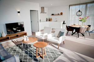 a living room with white chairs and a table at Bergvliet Villa's in Oosterhout