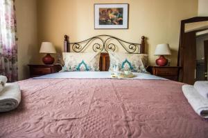 a bedroom with a large pink bed with two lamps at Elizabeth's Place in Heraklio