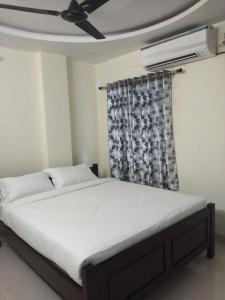 a bedroom with a bed with a ceiling fan at Feel like home -Guest House near Tenneti park in Visakhapatnam