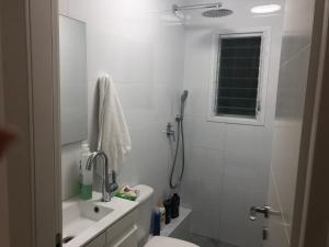 a bathroom with a shower and a toilet and a sink at The Urban Apartment in Haifa