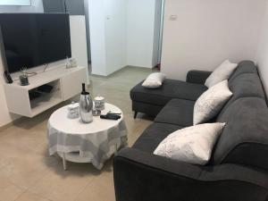 a living room with two couches and a tv at The Urban Apartment in Haifa