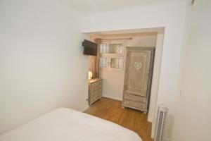- une chambre avec un lit, une commode et une porte dans l'établissement PROMENADE HOLIDAY - OLD TOWN PANORAMIC, à Nice