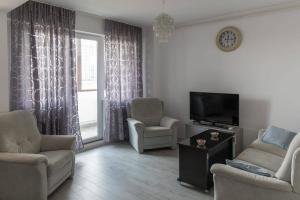 a living room with two chairs and a television at Studio Apartment in Chiajna