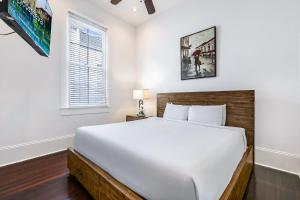 - une chambre avec un grand lit blanc et une fenêtre dans l'établissement Modern 2BR on Carondelet by Hosteeva, à La Nouvelle-Orléans