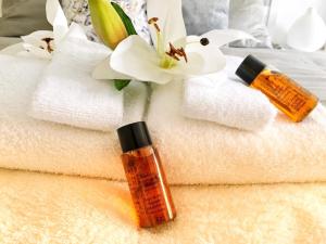 a pile of towels with a bottle of sunscreen and a flower at Odisey in Postojna