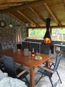 einen Holztisch mit Stühlen und einen Kamin in der Unterkunft Srub Bublava 155 in Bublava