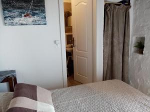 ein Schlafzimmer mit einem Bett und einer Tür zu einem Bad in der Unterkunft Pirate's Nest Stone House in Korčula
