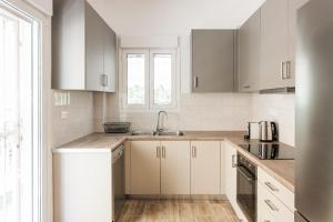 a kitchen with white cabinets and a sink at Bright 2BD Apartment in Psychiko by UPSTREET in Athens