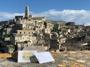 Un libro seduto su una roccia di fronte a una città di L’ Alba Sulla Murgia a Matera