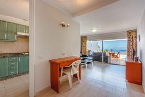 een keuken met een bureau en een eetkamer met uitzicht op de oceaan bij Villas canarias con vista al mar in Adeje
