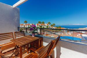 ein Balkon mit Tisch und Stühlen und Blick auf das Meer in der Unterkunft Apartment with ocean view in Costa Adeje in Adeje