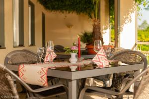 einen Tisch mit Stühlen und Weingläsern auf einer Terrasse in der Unterkunft Hotel Wasserschlößchen in Naumburg