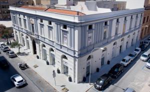 
a large white building sitting on top of a street at Historico Loft & Rooms Palazzo Adragna XIX in Trapani

