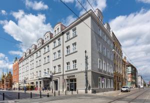 a large white building on the corner of a street at Korona Hotel Wroclaw Market Square in Wrocław