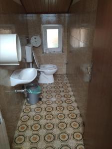 uma casa de banho com um WC, um lavatório e uma janela em Gostišče Oddih em Solkan