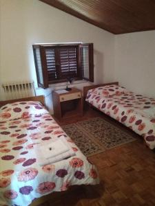 a bedroom with two beds and a window and a table at Gostišče Oddih in Solkan