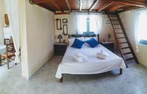 a bedroom with a white bed with blue pillows at Zoes House in Kyra Panagia