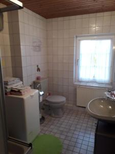 Ferienhof zur alten Linde في Holtgast: حمام مع مرحاض ومغسلة ونافذة