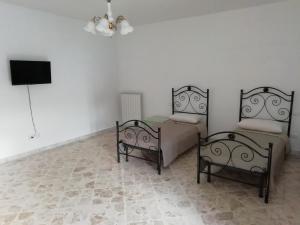 a bedroom with two beds and a flat screen tv at B&B Belle Donne in Palazzo San Gervasio