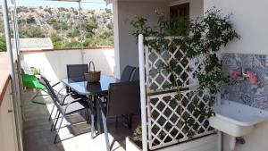 a balcony with a table and a sink at SOLE MIO Vacation in San Vito lo Capo