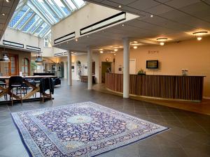 a large room with a rug on the floor in a building at Hotel Schaumburg in Holstebro