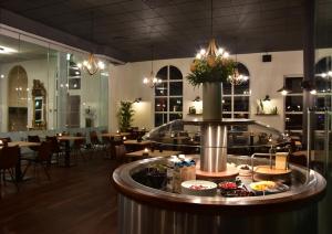 a restaurant with a counter with food on it at Hotel Schaumburg in Holstebro