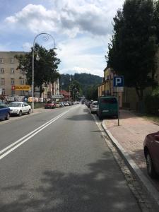 uma rua da cidade com carros estacionados na berma da estrada em APARTHOTEL KRYNICA em Krynica-Zdrój