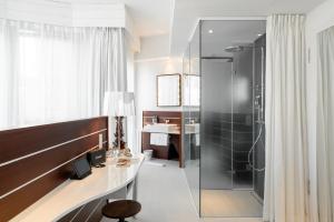 ein Bad mit einer Dusche, einem Schreibtisch und einem Waschbecken in der Unterkunft Ruby Lotti Hotel Hamburg in Hamburg