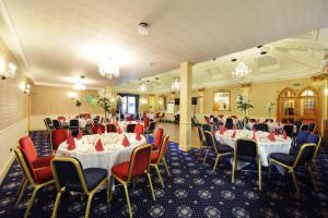 a banquet room with tables and chairs and chandeliers at The Royal George Hotel in Perth