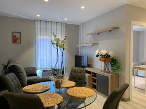 un soggiorno con 2 tavoli e un divano di Apartamentos m.bell a León