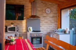 a kitchen with a table and a stove and a clock at Guest House Vasilena Самостоятелно наемане FREE PARKING in Sapareva Banya