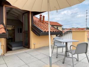 a table and two chairs and an umbrella on a patio at Porta Ronca - B&B, Suites & Apts in Rho