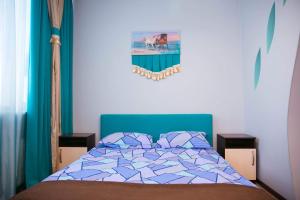 a bedroom with a bed with a blue comforter at Siesta Hotel in Kharkiv