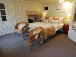 a bedroom with a large bed and a table and chairs at Longbridge House in Shepton Mallet