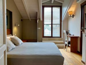 1 dormitorio con cama, escritorio y ventana en Porta Ronca - B&B, Suites & Apts, en Rho