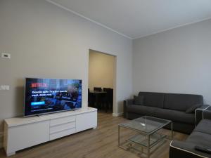 ein Wohnzimmer mit einem Sofa und einem Flachbild-TV in der Unterkunft Villa Allende in Forte dei Marmi