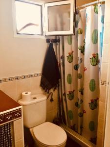 ein kleines Badezimmer mit Toilette und Fenster in der Unterkunft El atardecer in Puerto del Rosario