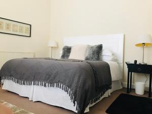 a bedroom with a bed with a black blanket at A Wee Cottage In Dunfermline in Dunfermline