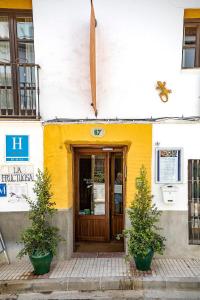 a yellow and white building with a door at La Fructuosa in Gaucín