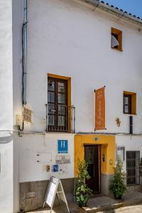 a white building with a sign in front of it at La Fructuosa in Gaucín