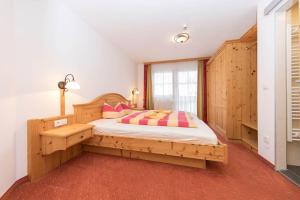 a bedroom with a wooden bed in a room at Hubertushof Ferienwohnungen in Gerlos