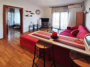 a living room with a red couch and a table at Philippos House in Florina